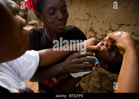 Un operatore sanitario vaccinati un bambino contro la polio nel villaggio di Gidan-Turu, del nord del Ghana giovedì 26 marzo, 2009. Foto Stock