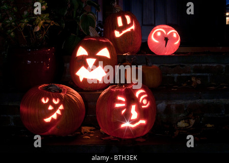 Quattro scolpite zucche / jack-o'-lanterne sedersi al di fuori di una casa in America. Foto Stock