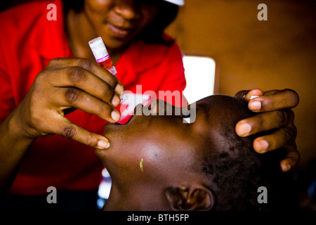 Un operatore sanitario vaccinati un bambino durante una nazionale di immunizzazione antipolio esercitare all'Moglaa scuola primaria Foto Stock