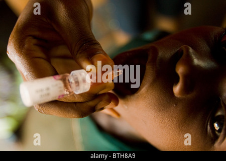 Un operatore sanitario vaccinati un bambino durante una nazionale di immunizzazione antipolio esercizio Foto Stock