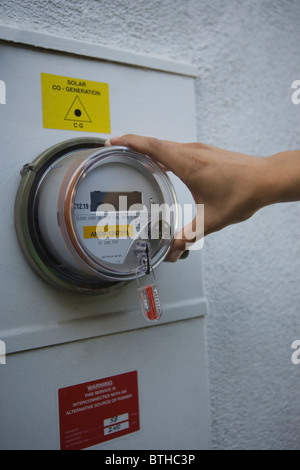 Mano sul misuratore di energia solare di unità di generazione di Los Angeles in California Foto Stock