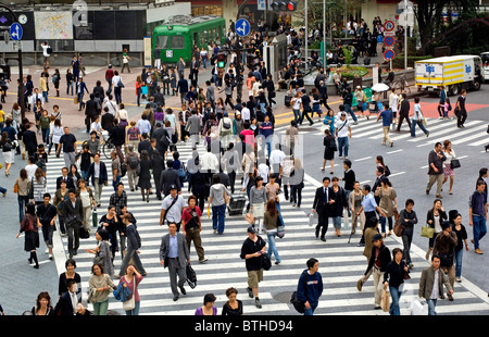 Le persone che attraversano una strada in Shibuya, Tokyo, Giappone Foto Stock