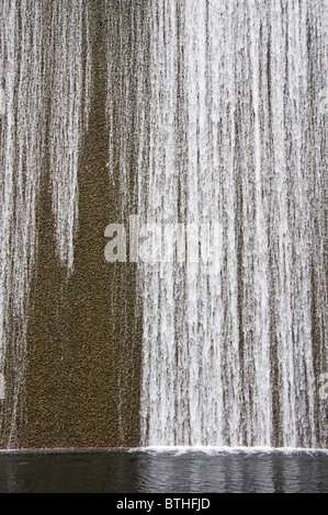 Acqua a cascata verso il basso fontana nel quartiere degli affari del centro di Singapore Foto Stock