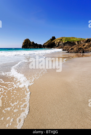 White surf dolcemente lambisce le immacolate sabbie di Kynance Cove, la lucertola, Cornwall Foto Stock