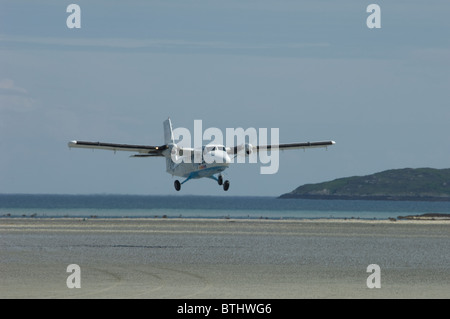 Un twin otter aereo decolla dall'shellstrand spiaggia di Barra pista di atterraggio per aerei, Ebridi Esterne, Scozia. SCO 6675 Foto Stock