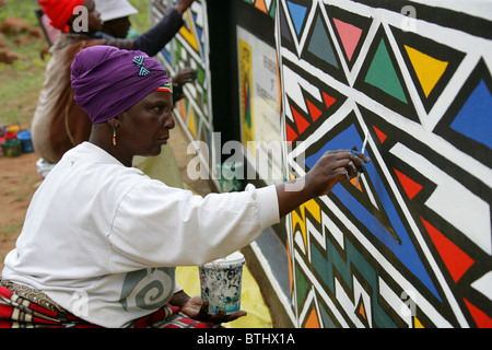 Ndebele donne pittura disegni tradizionali su pareti, Ndelebe Villaggio Culturale, Botshabelo, Sud Africa. Foto Stock