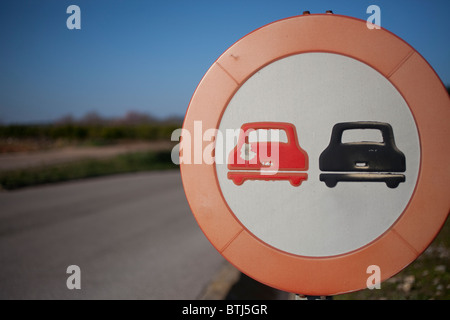 Un datato spagnolo cartello stradale con il vecchio stile di forme di auto, con bullet danni. Foto Stock