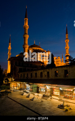 La Moschea Blu o di Sultan Ahmet Camii illuminata di notte con negozi Bazaar Istanbul quartiere di Sultanahmet Turchia Europa Foto Stock