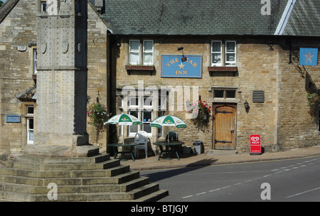 Lo Star Inn, sotto l'ombra della regina Eleonora Croce, a Geddington, Northamptonshire, Regno Unito Foto Stock