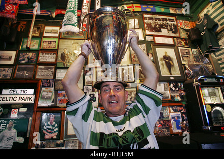 Ventola celtica in possesso di una copia del 1967 Coppa Europa Trofeo, Bairds Bar aka "Il Celtic Pub', Glasgow, Scozia Foto Stock