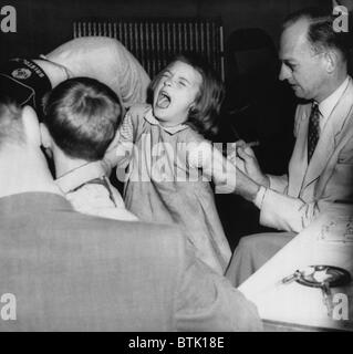 Una giovane ragazza che riceve un vaccino dal dott. Hugh Griffin (destra), circa 1950s. Archivi CSU/cortesia Everett Collection Foto Stock