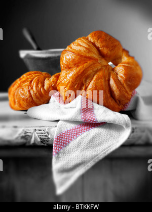 Croissant francesi tradizionali appena cotti pronti a mangiare. In un ambiente rustico cucina. Foto Stock
