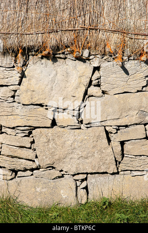 In pietra a secco muro di casa e paglia. Onacht, Inishmore, Isole Aran, nella contea di Galway, Connaught, Irlanda. Foto Stock