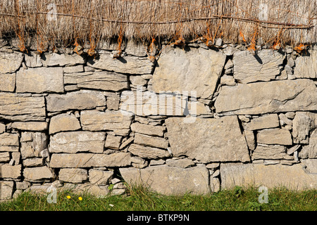 In pietra a secco muro di casa e paglia. Onacht, Inishmore, Isole Aran, nella contea di Galway, Connaught, Irlanda. Foto Stock