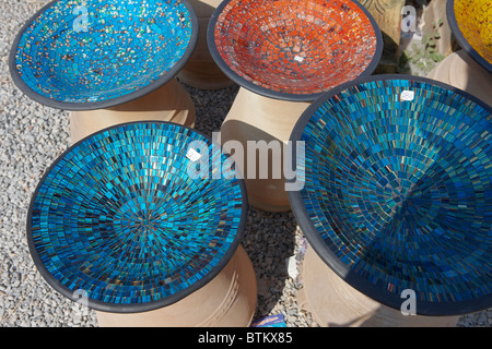 Una selezione di ciotole in ceramica poco profonde fatte a mano decorate con mosaici esposti all'aperto su una banchina del mercato. Creta, Grecia. Foto Stock