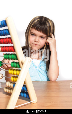 Una giovane ragazza di matematica di apprendimento utilizzando una regola di scorrimento. Tutti gli isolati su sfondo bianco Foto Stock