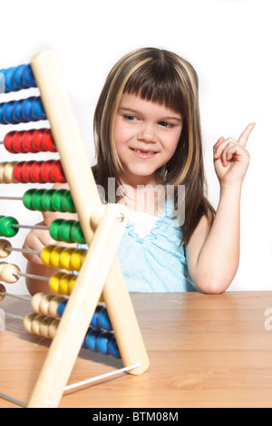 Una giovane ragazza di matematica di apprendimento utilizzando una regola di scorrimento. Tutti gli isolati su sfondo bianco Foto Stock