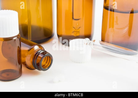 Una raccolta di vetro ambra remedy bottiglie (spray, gocciolatore e pillola) e pillules utilizzato in homoeopathic farmacia. Foto Stock