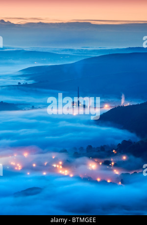 La Lafarge opere in cemento e luci di Castleton nella nebbia, Hope Valley, il Parco Nazionale di Peak District, Derbyshire, England, Regno Unito Foto Stock