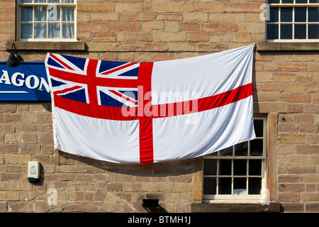 Alfiere bianco o St George's Alfiere Bandiera normalmente volato su British Royal Navy navi o gli stabilimenti a terra il suo visto al di fuori del pub Foto Stock