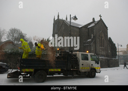 Consiglio lavoratori spandimento di sale e graniglia su una strada congelati a Castlebar, Co. Mayo, Irlanda Foto Stock