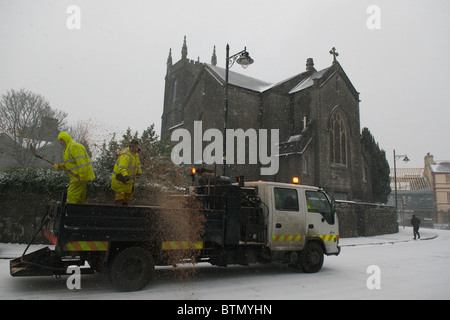 Consiglio lavoratori spandimento di sale e graniglia su una strada congelati a Castlebar, Co. Mayo, Irlanda Foto Stock