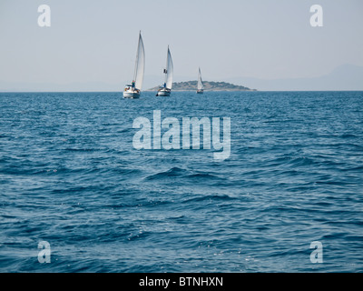 Tre velieri provenienti verso la telecamera in blu oceano costa greca Foto Stock