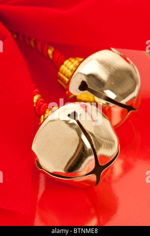 Natale campane e nastro con sfondo rosso Foto Stock