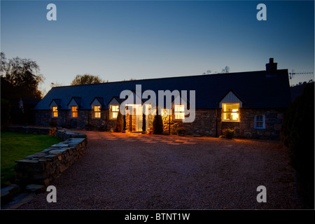 Il Steading di notte illuminata rurale Highland Cottage uno piani Inverey home borgo, Braemar, Cairngorms National Park, Scotland, Regno Unito Foto Stock