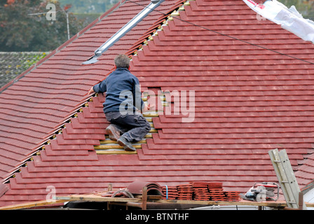 Builder lavorando sul tetto di tegole Foto Stock