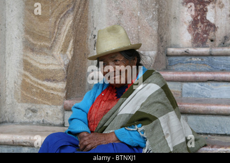 Ritratto di una vecchia donna ecuadoriana seduta su gradini di marmo in un abito blu e cappello di Panama a Cuenca, Ecuador Foto Stock