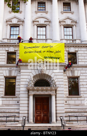 Quattro i manifestanti di Greenpeace scala il ministero del Tesoro e distendere un banner per evidenziare problemi di verde Foto Stock