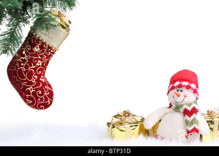 Calza di Natale e pupazzo di neve con doni su sfondo bianco. Foto Stock