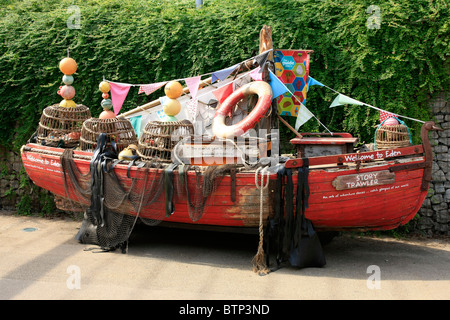 Un vecchio Cornish barca da pesca caricato con tutte le cose e di pesca relative al mare come una mostra d'Arte presso l'Eden Project Foto Stock