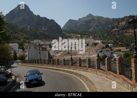 Spagna, Andalusia Grazalema, auto in movimento su strada con il villaggio e le montagne sullo sfondo Foto Stock