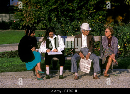 Studenti francesi, francese, francese, francese giovane, uomo, donna seduta su una panchina nel parco, città di Nimes, Languedoc-Roussillon, Francia, Europa Foto Stock