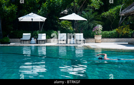 Piscina presso il Melia Bali Hotel, Nusa Dua Bali Indonesia con una persona di nuoto Foto Stock