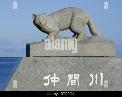 Iriomote Wildcat scultura in pietra sul ponte che attraversa il fiume Nakama, Iriomote isola, a Okinawa, Giappone Foto Stock
