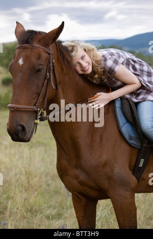 Giovane donna su un cavallo Foto Stock