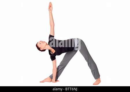 Montare la giovane donna facendo esercizi yoga triangolo chiamato pongono (nome sanscrito: Trikonasana), isolati su sfondo bianco. Foto Stock