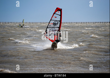 Windsurf rendendo più di venti forti nell'estuario del Tamigi, Essex, Regno Unito. Foto Stock