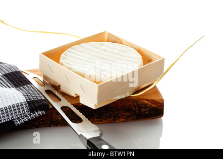 Formaggio Camembert in cassetta di legno sul tagliere con asciugamano e Coltello per formaggio, isolato su sfondo bianco Foto Stock