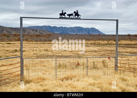 Ranch gate sul deserto del Chihuahuan vicino presidio, Texas, Stati Uniti d'America con la Sierra grande massiccio in tutta Rio Grande in Messico in dist, inverno Foto Stock