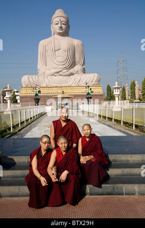 Monaci buddisti tibetani e le monache che posano per una foto davanti alla grande statua del Buddha, Bodhgaya,, Bihar, in India. Foto Stock