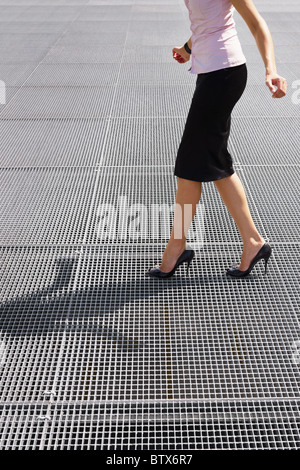Vista laterale del business donna in equilibrio su tacchi alti. Spazio di copia Foto Stock