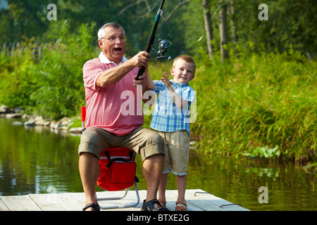 Foto del nonno e nipote di gettare la pesca in ambiente naturale Foto Stock