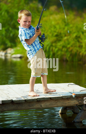 Foto di capretto piccolo asta di trazione mentre la pesca sul weekend Foto Stock