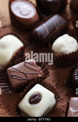 Vari tipi di praline isolato su sfondo di cioccolato Foto Stock