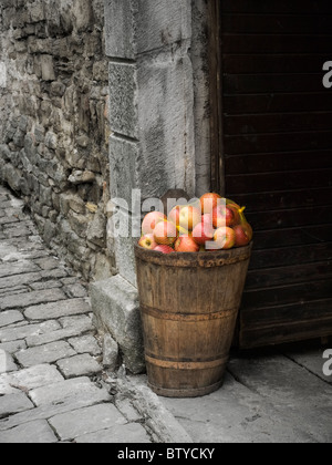 Mela matura nel cestello mediante la porta su una strada di pietra ... Foto Stock