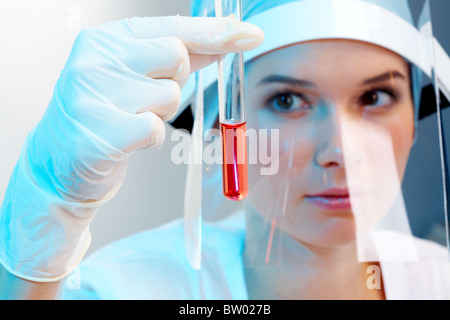 Close-up di tubo di vetro con il fluido in un infermiere mano durante il test medici Foto Stock